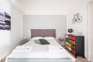 una camera bianca con un grande letto e una bicicletta sul muro di AP Appartamenti Urbik a Bologna