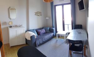 een woonkamer met een bank en een tafel bij Bord de plage, thalasso et vue mer ! in Cabourg