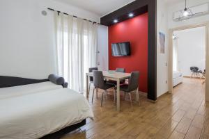 una camera da letto con tavolo e parete rossa di Pompei Centrum a Pompei