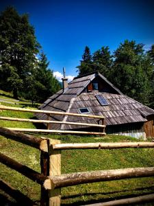 an old barn with a fence in front of it at Suška Koča in Stahovica