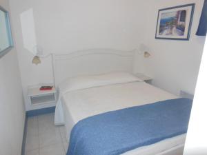 a bedroom with a white bed and a blue blanket at Luxury apartment in Port Grimaud in Grimaud