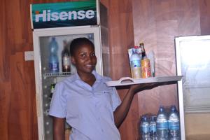 a woman holding a book in front of a refrigerator at The Dreamer Hotel in Dar es Salaam