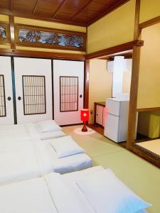 a room with four beds and a red candle at B&B MIKAWA - Kanazawa Fish Harbour in Kanazawa