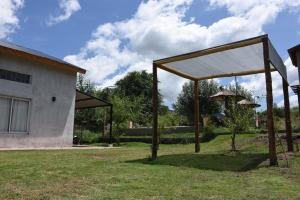 a pavilion in a yard next to a building at Encanto Puntano in Potrero de los Funes