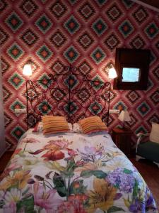 1 dormitorio con 1 cama con pared estampada en Hotel Rural El Marquesito Antigua Casa Carmela, en Arenas de San Pedro