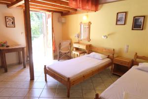 a bedroom with two beds and a desk and a window at Taxiarchis Apartments in Skiathos