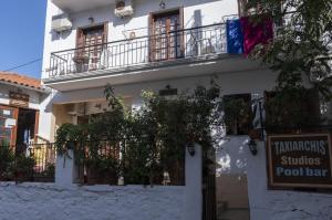 a white building with a sign in front of it at Taxiarchis Apartments in Skiathos