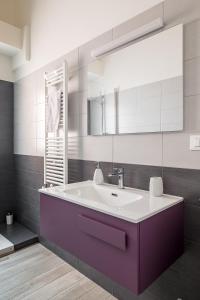 een badkamer met een wastafel en een spiegel bij AP Appartamenti in Bologna