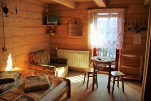a living room with a bed and a couch and a window at U Sarapatki-Noclegi z wyżywieniem in Jurgów
