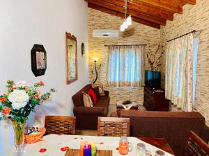 a living room with a couch and a table with flowers at Ermones Amber Villa in Vátos