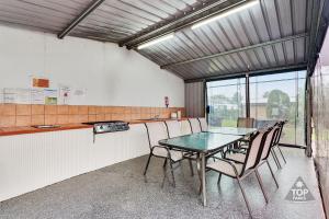 a dining room with a table and chairs at Fossicker Caravan Park in Glen Innes