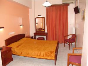 a bedroom with a bed and a dresser and a mirror at Hotel Cosmos in Athens