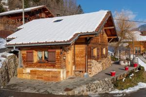 a log cabin with a snow covered roof at Chalet Dreamtime in Les Villards-sur-Thônes