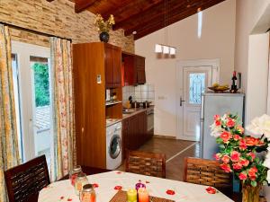 a kitchen with a table and a kitchen with a refrigerator at Ermones Amber Villa in Vátos