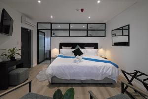 a bedroom with a large bed with white sheets at Point B Guest House in Cape Town