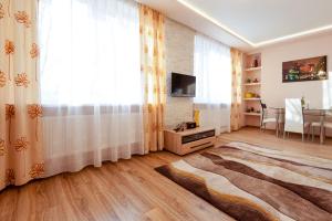 a living room with a large window and a table at Piast Apartament in Kraków