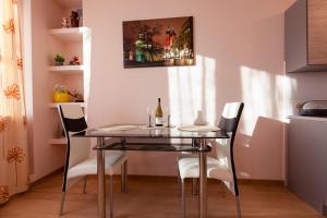 una mesa de comedor con sillas y una botella de vino en Piast Apartament, en Cracovia