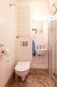 a white bathroom with a toilet and a sink at Piast Apartament in Kraków