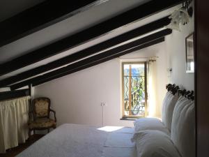 a bedroom with a bed with white sheets and a window at Villa Pietrafiore in Monterosso al Mare