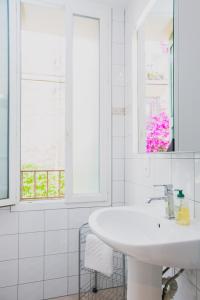 a white bathroom with a sink and a window at Regina's Banyuls - Spatious apartment next to the beach in Banyuls-sur-Mer