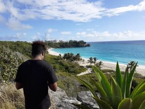 a man standing on a hill looking at the beach at The Pool House in Saint Philip