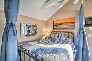 a bedroom with a bed with blue curtains at Idyllic Waterfront Cottage with Beach and Sunset Views! in Port Townsend