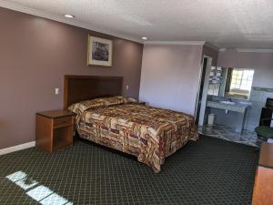a bedroom with a bed and a table in a room at Passport Inn in Whittier