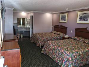 a hotel room with two beds and a sink at Passport Inn in Whittier