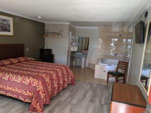 a bedroom with a bed and a bathroom with a sink at Passport Inn in Whittier