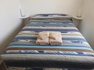 Una cama con toallas encima. en Warrawong on the Darling Wilcannia Holiday Park, en Wilcannia