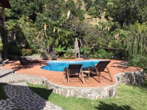 a patio with a table and chairs next to a pool at Casa Wenche in Santa Cruz La Laguna