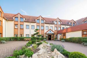 a large building with a courtyard with flowers at Best Western Erfurt-Apfelstädt in Erfurt
