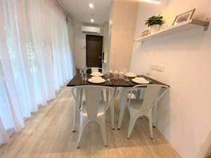 a dining room with a black table and white chairs at Shipping Container Hotel at Haw Par Villa GoogleMap Address 27 Zehnder Road Taxi and cars can only enter via Zehnder Road in Singapore