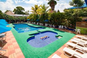 an image of a swimming pool with chairs around it at Ayenda 1132 Copiclub in Ibagué