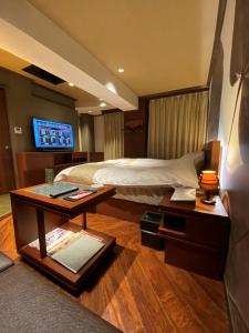 una habitación de hotel con una cama y una mesa con una mesa en Hotel Venus Neo, en Nagoya