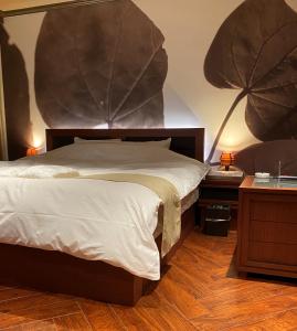 ein Schlafzimmer mit einem großen Bett und zwei Nachttischen in der Unterkunft Hotel Venus Neo in Nagoya