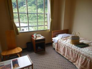 ein Hotelzimmer mit 2 Betten und einem Fenster in der Unterkunft Onyado Tsutaya in Kiso