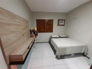 a bedroom with a bed and a wooden headboard at Casa de Praia Luis Correia in Luis Correia