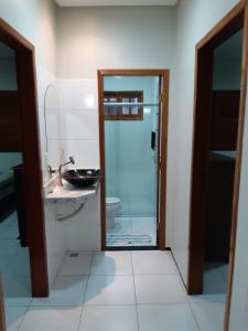 a bathroom with a sink and a toilet and a mirror at Casa de Praia Luis Correia in Luis Correia