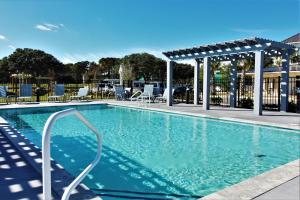 a swimming pool with chairs and a pavilion at Beacon Quarters by KEES Vacations in Corolla