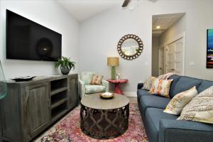 sala de estar con sofá azul y TV en Beacon Quarters by KEES Vacations, en Corolla