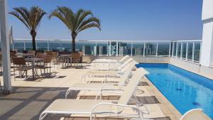 a hotel patio with chairs and a swimming pool at Saint Moritz - flat particular a 05 min da Esplanada in Brasília