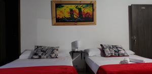 a room with two beds and a picture on the wall at Gemas San Joaquin 1 in Medellín