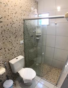 a bathroom with a toilet and a glass shower at Pousada Paraíso Maragogi in Maragogi +31 photos
