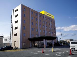 a hotel building with a parking lot in front of it at Smile Hotel Shizuoka Yoshida Inter in Yoshida