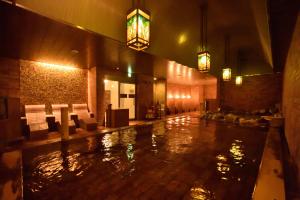 - un hall avec une piscine d'eau dans un bâtiment dans l'établissement Dormy Inn Premium Otaru, à Otaru