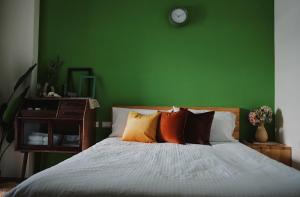 a green bedroom with a bed and a green wall at Easy Life B&B in Taitung City