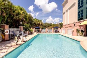 a swimming pool with chairs and a building at Holiday Inn Express & Suites Bradenton East-Lakewood Ranch, an IHG Hotel in Bradenton