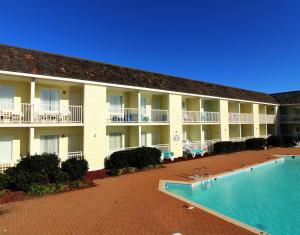 a large building with a swimming pool in front of it at Villas of Hatteras Landing by KEES Vacations in Hatteras