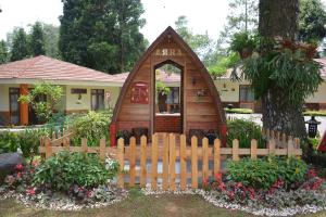 a small house with a wooden fence in a yard at Arra Lembah Pinus Ciloto in Puncak